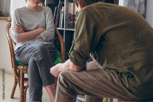 family conflict. Couple discussing sitting near bookshelves