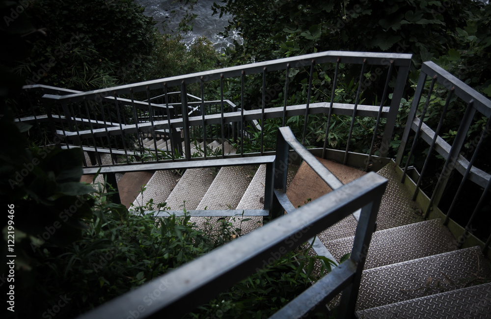 Obraz premium Rusty stairs followed from the forest to the coast