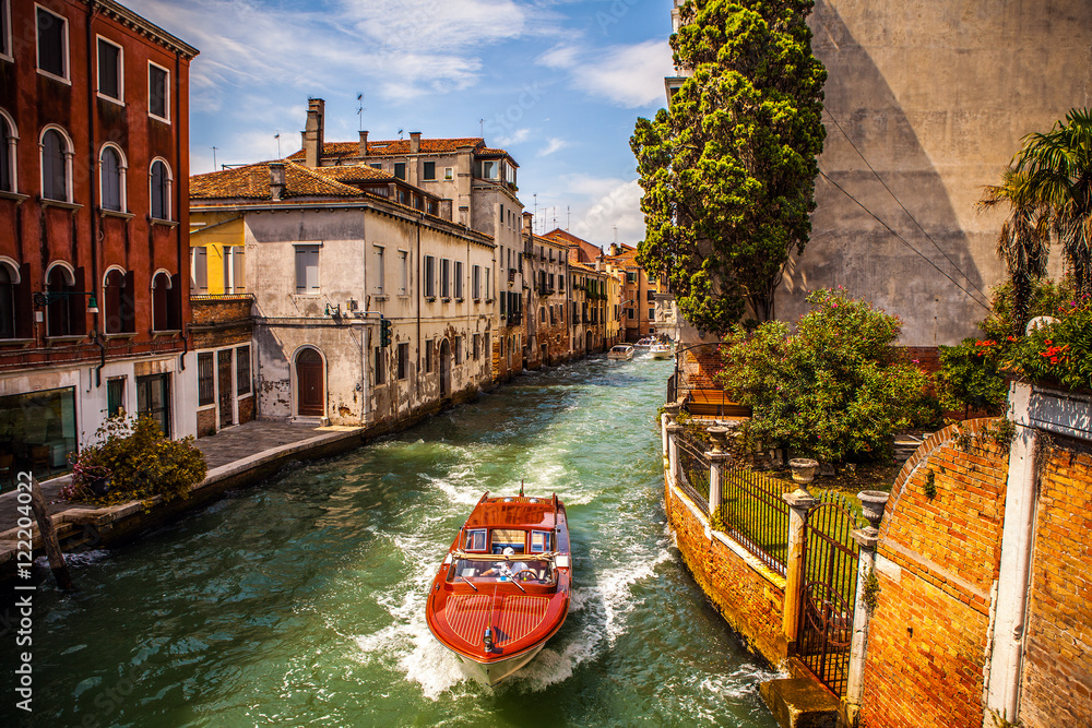 Naklejka premium VENICE, ITALY - AUGUST 17, 2016: Retro brown taxi boat on water in Venice on August 17, 2016 in Venice, Italy.