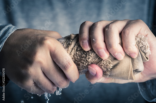 タオルを絞る男性の手 photo