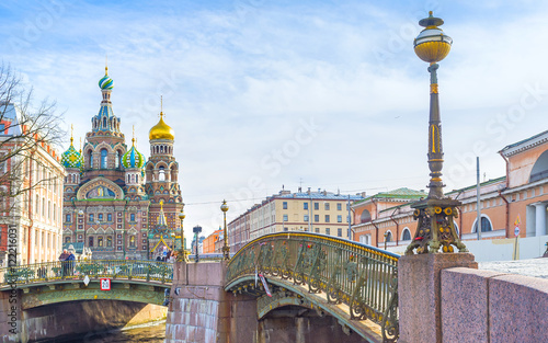 : The scenic old fashioned streetlight on Malokonushenny bridge with the Church on Spilled Blood on the background photo