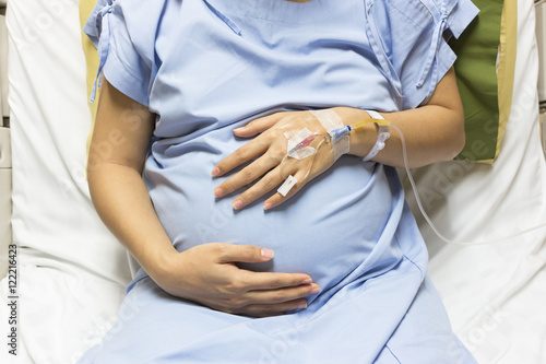 Asian Pregnant Woman patient is on drip receiving a saline solut