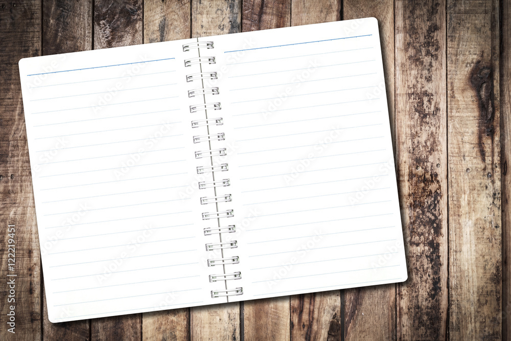 Open notebook paper with line on wood background for design with copy space for text or image. Open notebook paper with line on wood background for design with copy space for text or image.