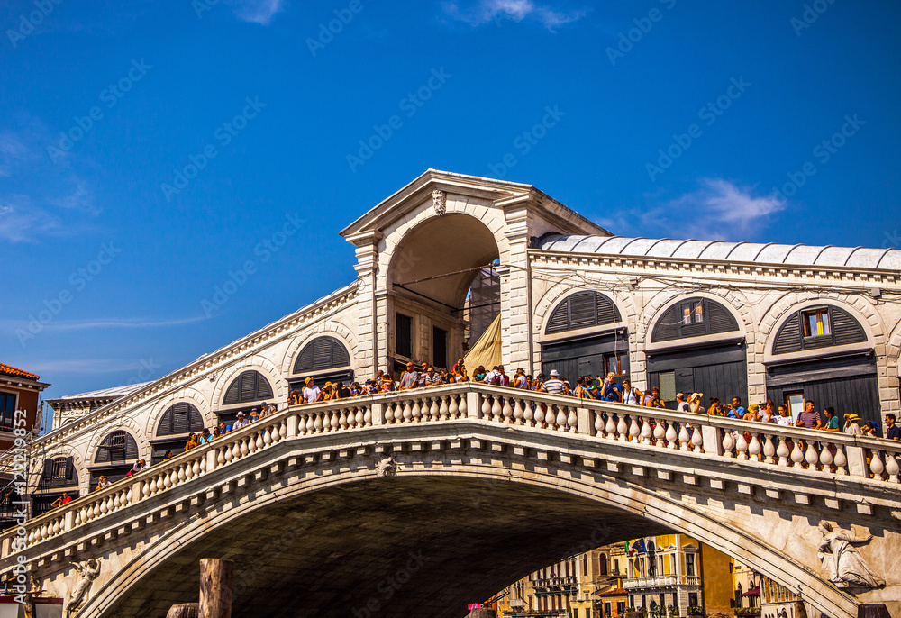 VENICE, ITALY - AUGUST 17, 2016: View on the cityscape and lovely bridge on the canal of Venice on August 17, 2016 in Venice, Italy.
