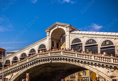 VENICE, ITALY - AUGUST 17, 2016: View on the cityscape and lovely bridge on the canal of Venice on August 17, 2016 in Venice, Italy.