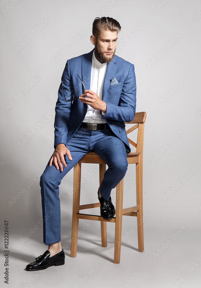 Young handsome man in a suit sitting on a chair