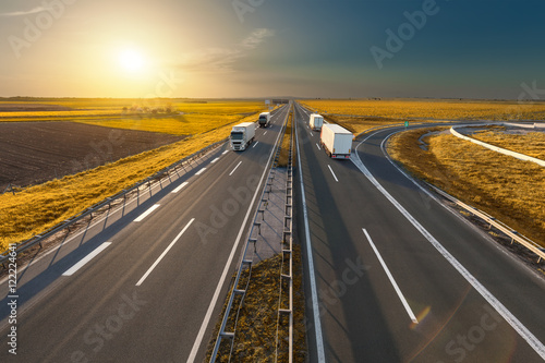 White trucks on the freeway at idyllic sunset