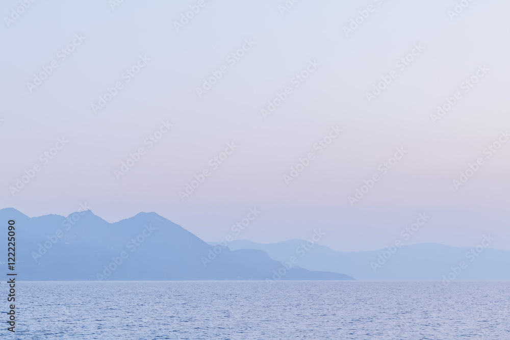 Mountain silhouettes from the sea landscape with place for your design