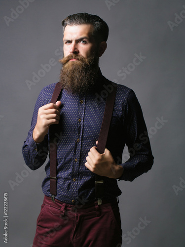 Fotografi Trendy man holds suspenders