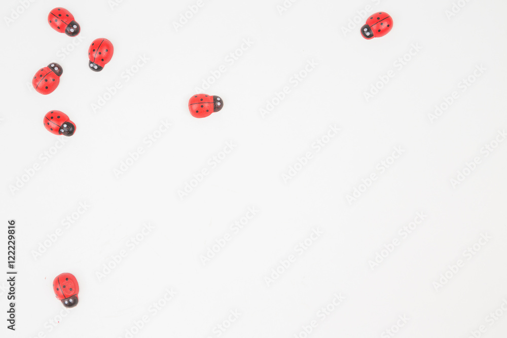 Small toy red ladybugs. Top view from above. White background paper. Template for your banner