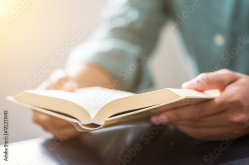 Young man is sitting reading a book

