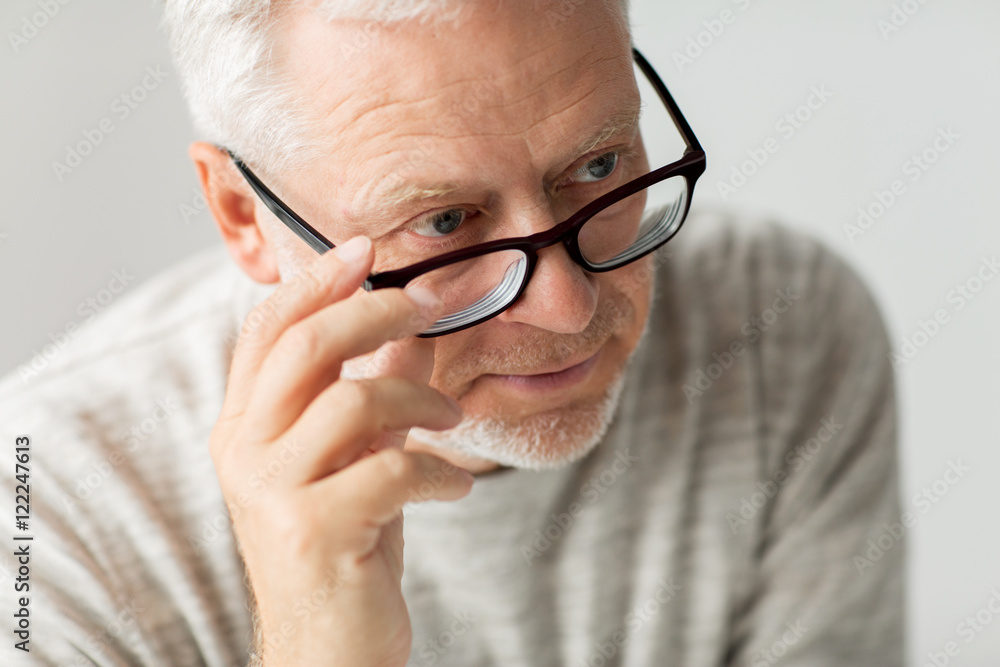 close up of senior man in glasses thinking close up of senior man in glasses thinking