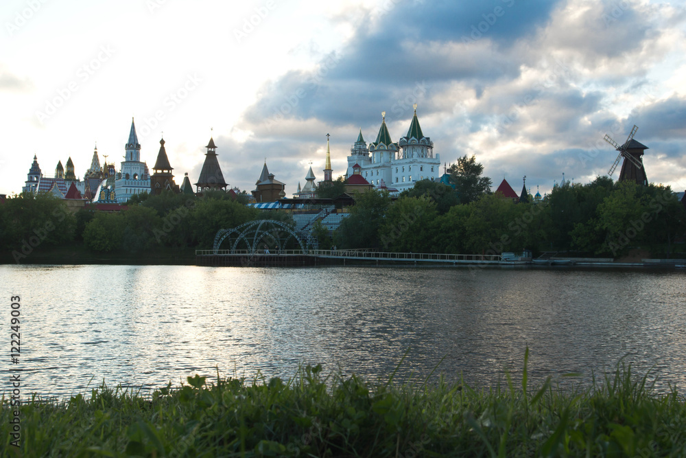 wooden mill and Kremlin on the banks of the river in evening wooden mill and Kremlin on the banks of the river in evening