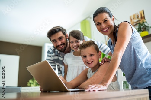 Portrait of happy family using laptop in the living room 