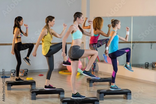 Fototapeta Naklejka Na Ścianę i Meble -  Group of women exercising on aerobic stepper