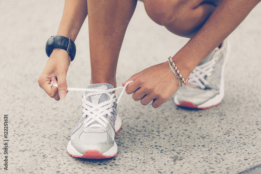 Woman tying sports shoe Woman tying sports shoe