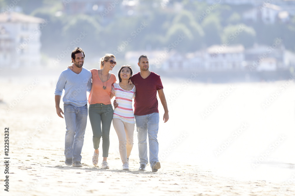 Group of friends walking on the beach