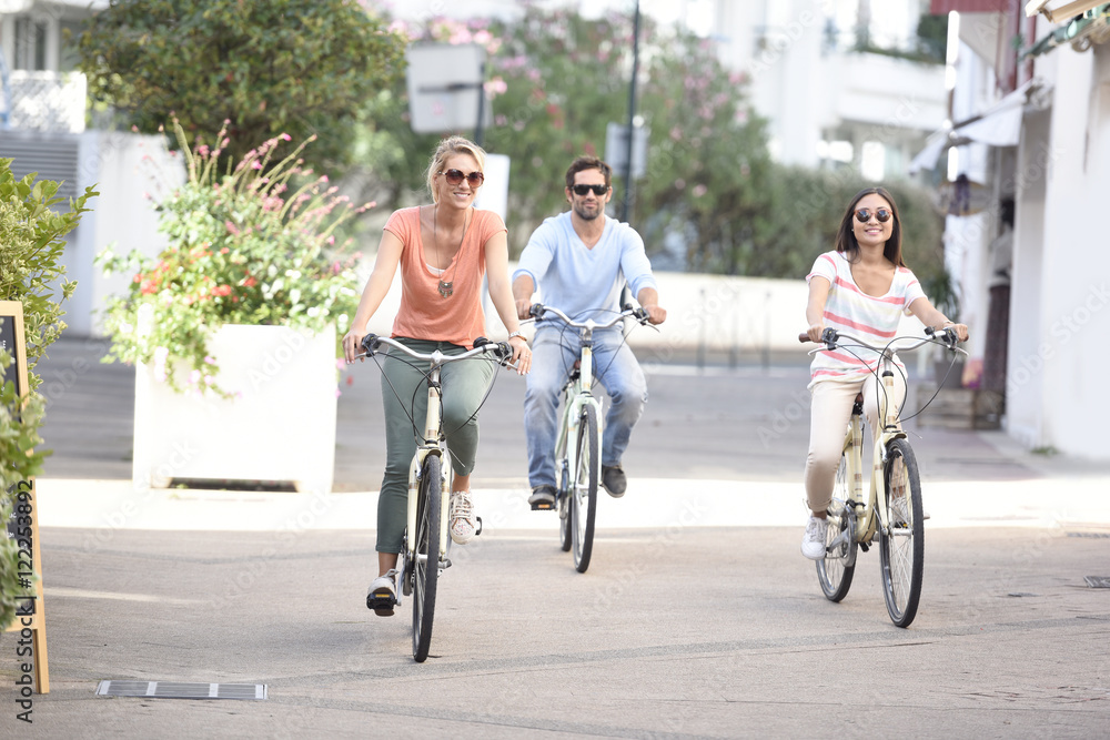 People on vacation riding bicycles in town street