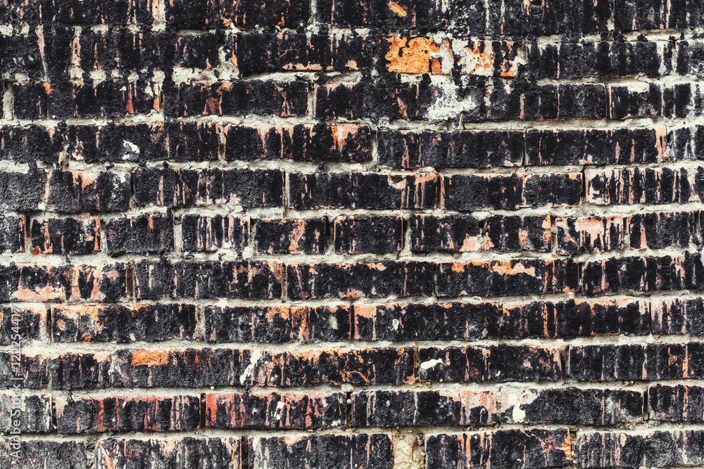 Weathered stained old dark brick wall, texture grunge background