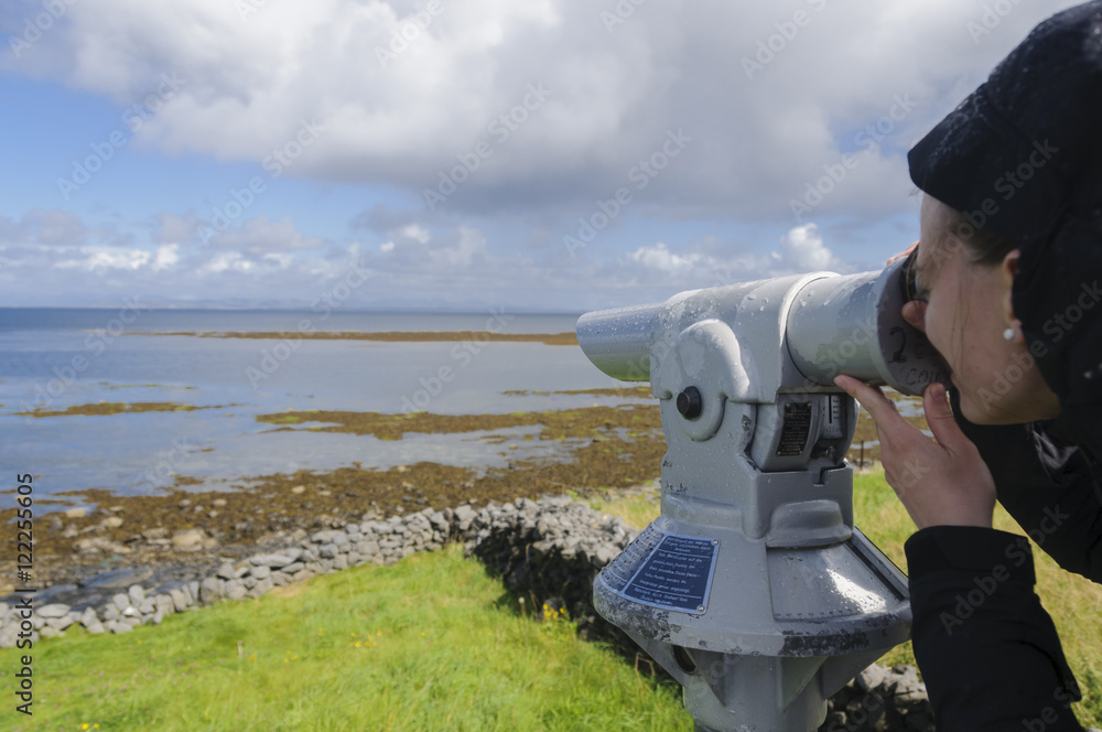 Obraz premium Girl looking through spyglass