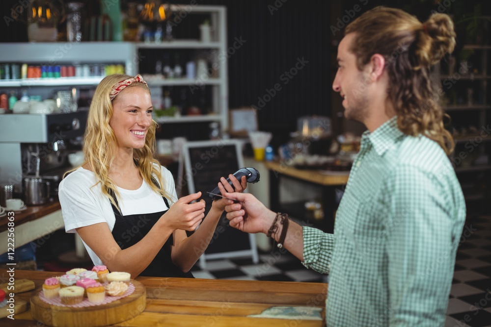 Fototapeta premium Happy customer giving credit card to waitress