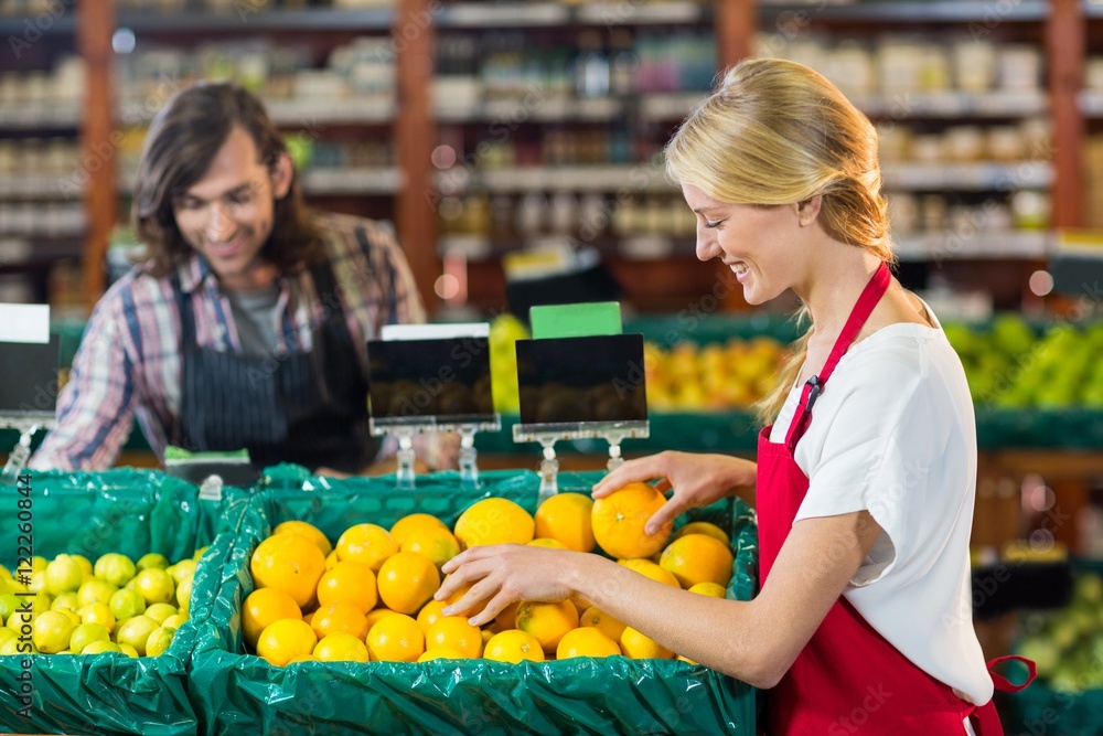 Fototapeta premium Female staffs checking fruits in organic section