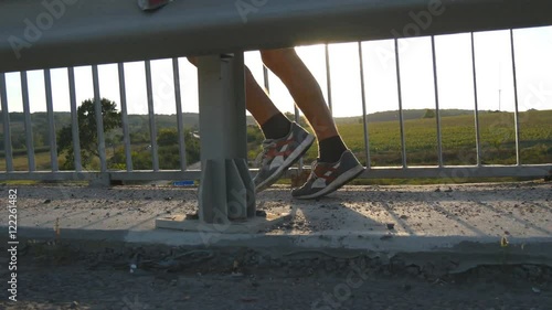 Wallpaper Mural Feet of strong man running on a bridge in countryside. Male legs jogging during workout training on country route at sunset. Male athletes jogs along pedestrian bridge. Working out outdoors, close up Torontodigital.ca