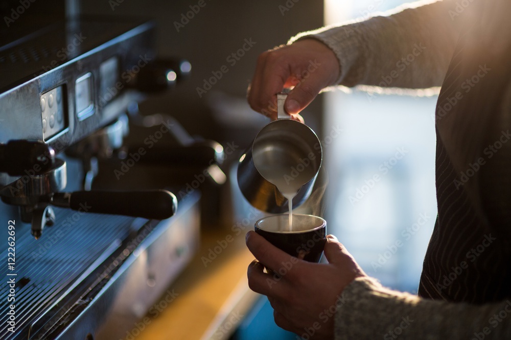 Φωτογραφία Waiter making cup of coffee at counter in cafe
