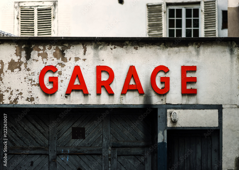 Fototapeta premium Old abandoned garage with red sign