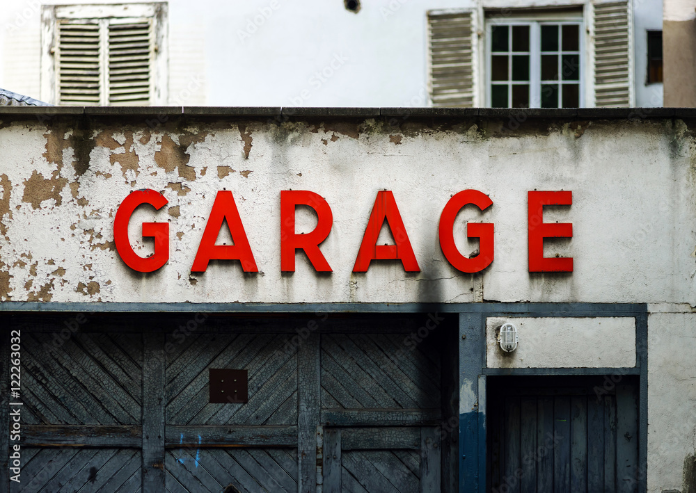Old abandoned garage with red sign