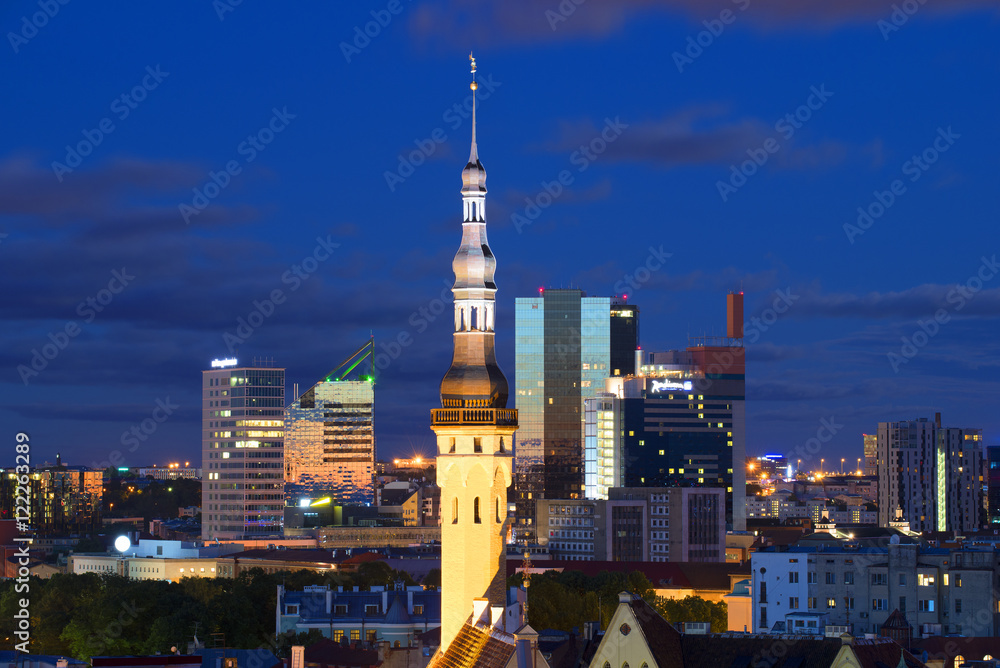 Obraz premium The spire of old city hall on the background of a modern city. Tallinn, Estonia