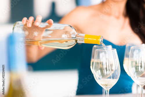 Foto Young Woman Bartender Pouring Wine Bottle