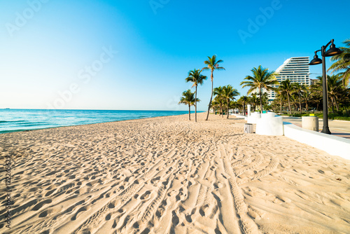 White sand deserted Fort Lauderdale South Florida beach stretching out under beautiful blue cloudless sky