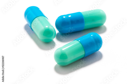 Three time-release blue green capsule pill medication antidepressant antiviral antibiotic isolated on white background