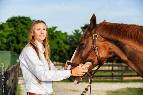Woman grooming horse on farm