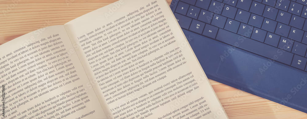 Obraz premium Schreibtisch / Arbeitsplatz mit Buch und Laptoptastatur, Breitbild retro