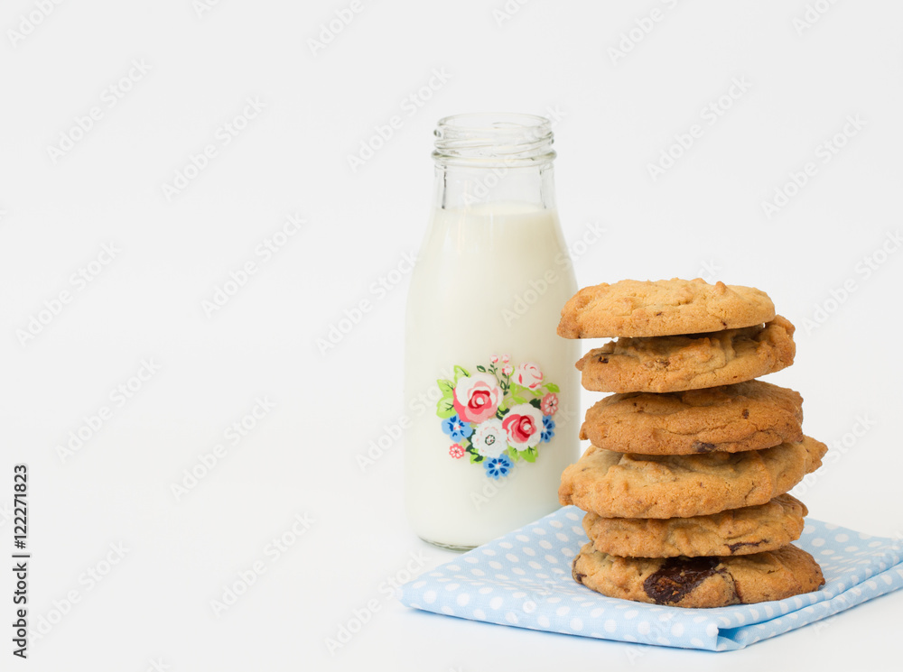 A snack time treat of homemade peanut butter and chocolate cookies and a small bottle of milk on a white, isolated background. A snack time treat of homemade peanut butter and chocolate cookies and a small bottle of milk on a white, isolated background.