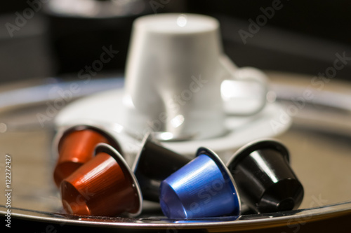 Coffee Capsules with cup in the background