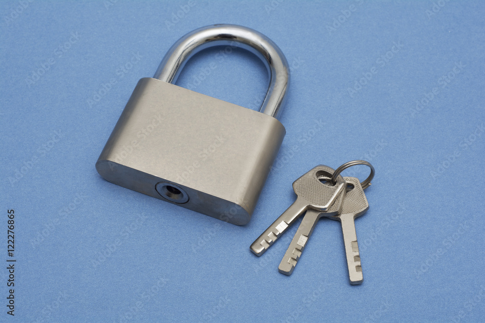 A Padlock with Keys isolated on blue background - security concept A Padlock with Keys isolated on blue background - security concept