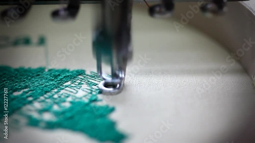 An extreme close up of a sewing machine embroidering fabric.