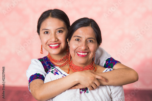 Valokuvatapetti Beautiful hispanic mother and daughter wearing traditional andean clothing, embr