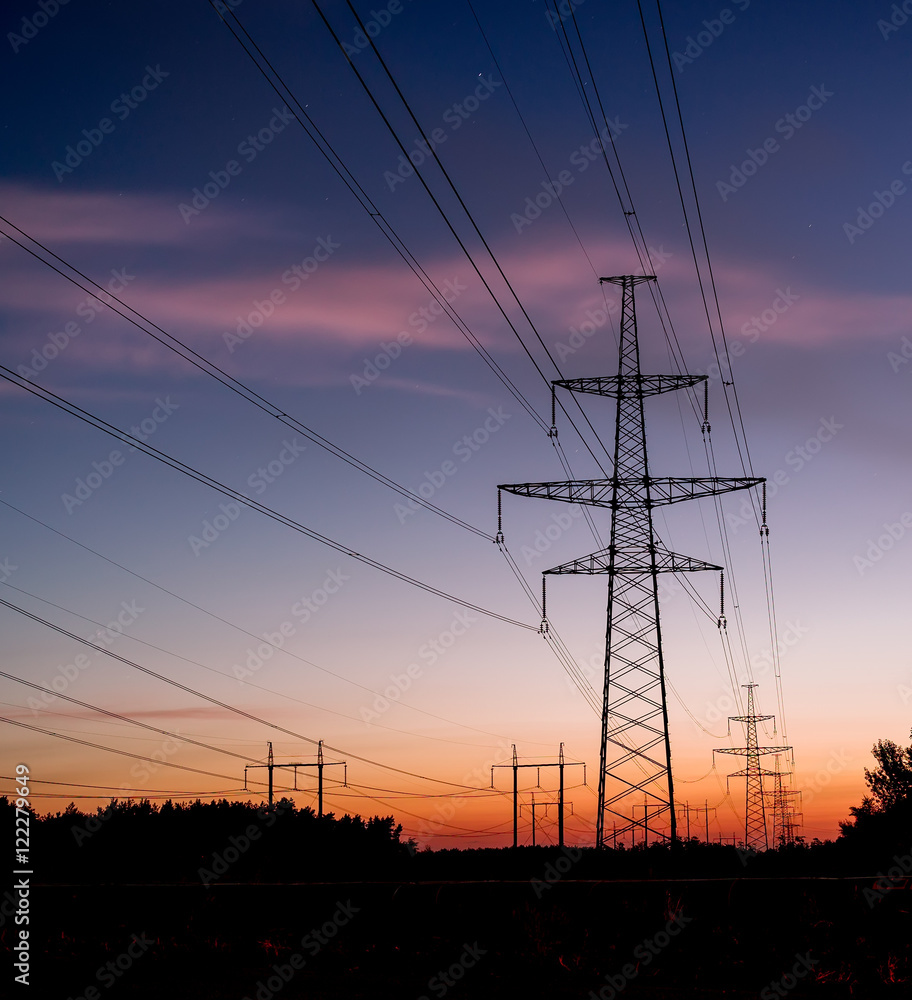 Electrical pylon and high voltage power lines at night.