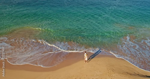 Aerial view of happy retired couple walking down the beach, vacation retirement concept photo