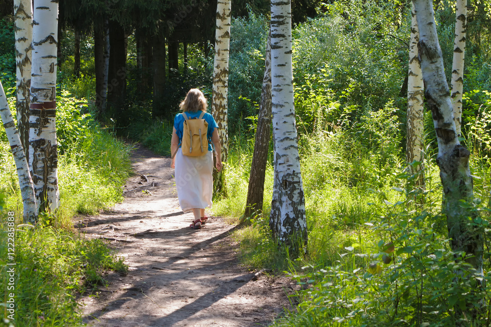 Adult woman in a forest park on the walk Adult woman in a forest park on the walk