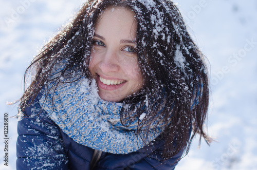 Portrait of a beautiful smiling girl with snow in her hair