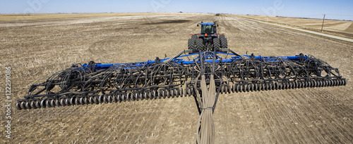 An air seeder and tractor in a field with blue sky,Alberta Canada