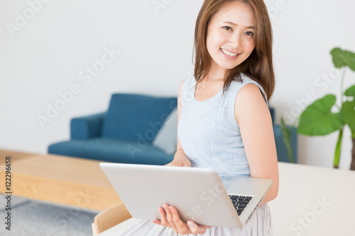 部屋でパソコンを見る女性