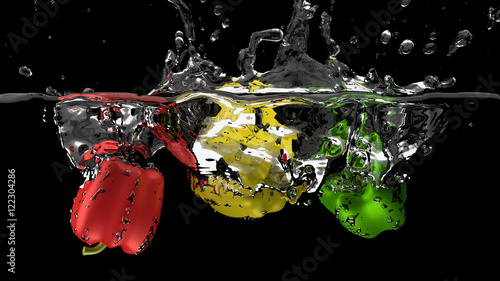 Bell peppers falling in water with splashes, isolated on black photo