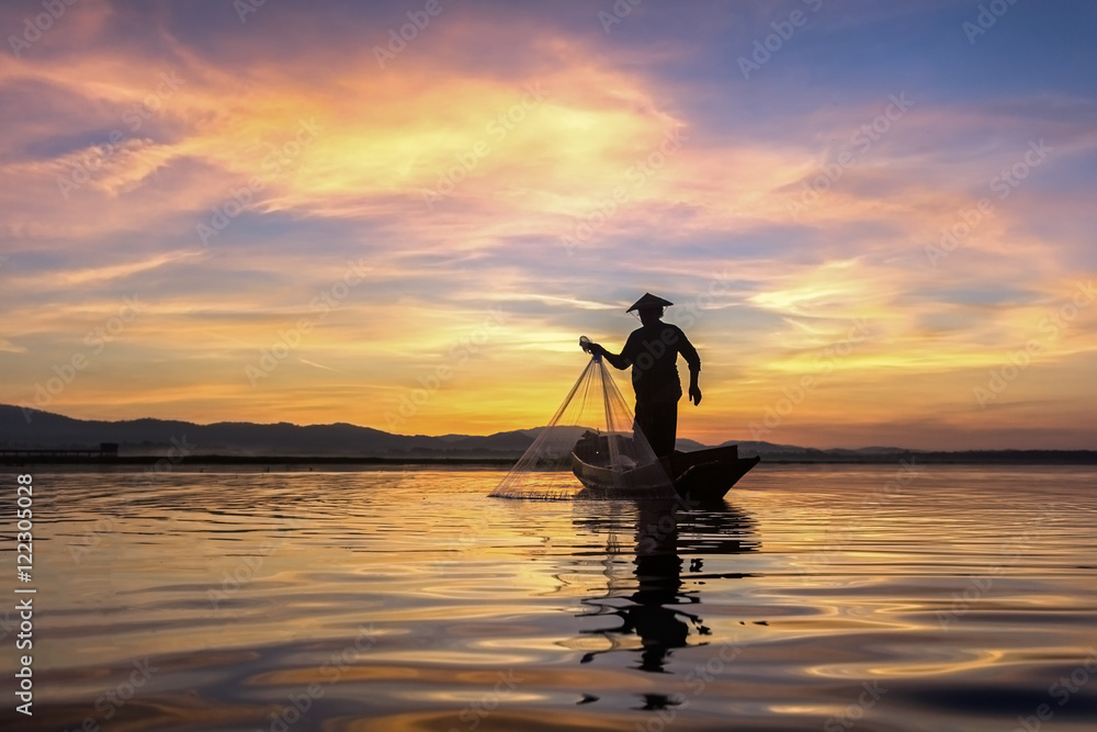 Silhouette fisherman on fishing boat setting net with sunrise