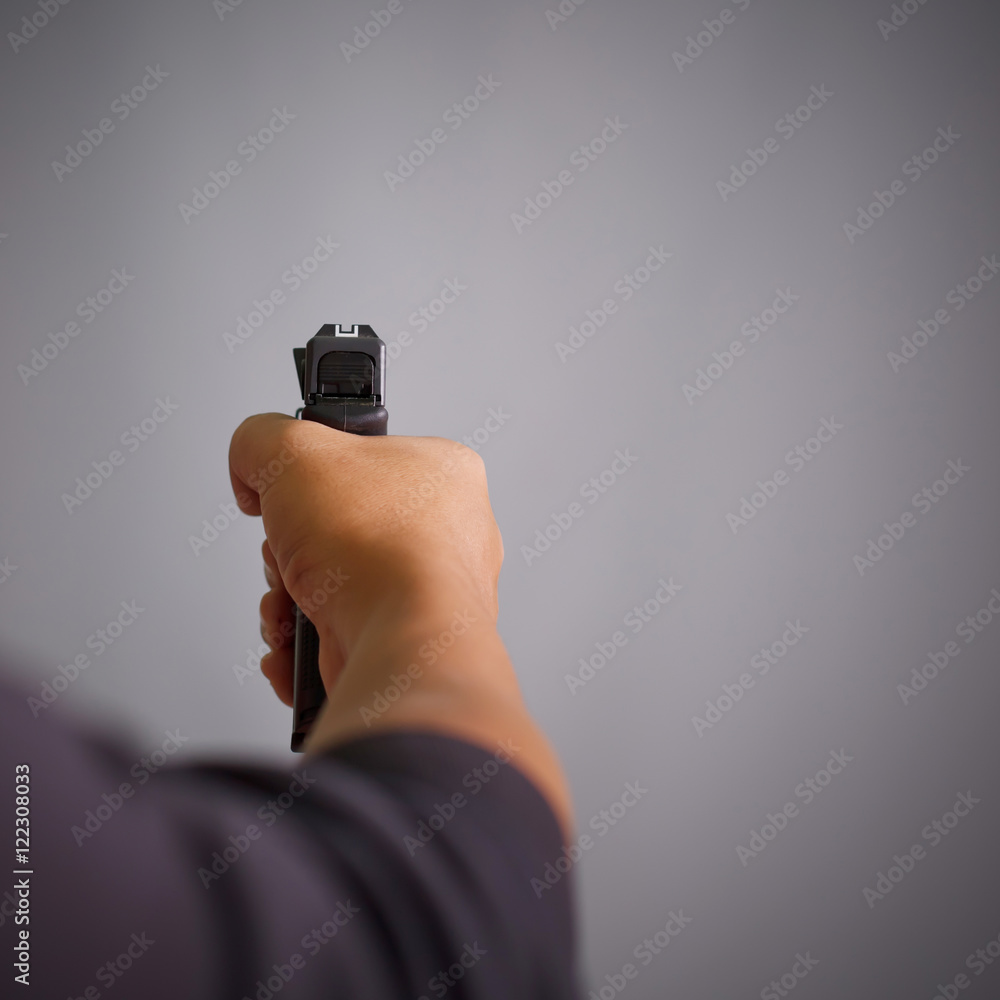 Man's hand holding gun